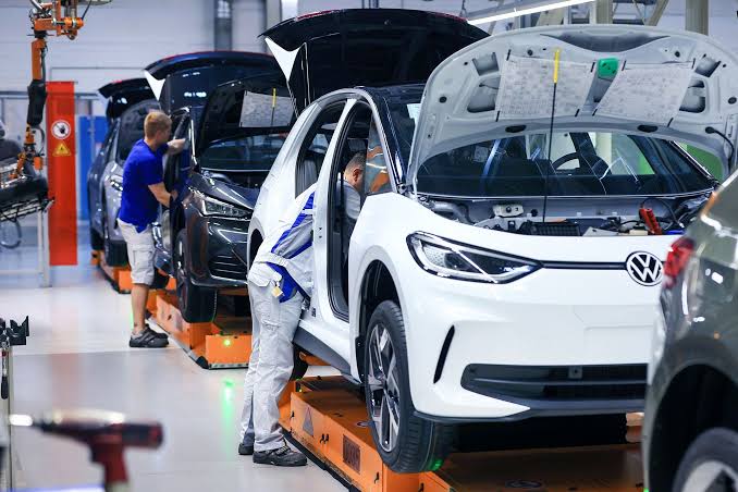 Operai al lavoro sulla linea di montaggio di un modello elettrico Volkswagen ID.4