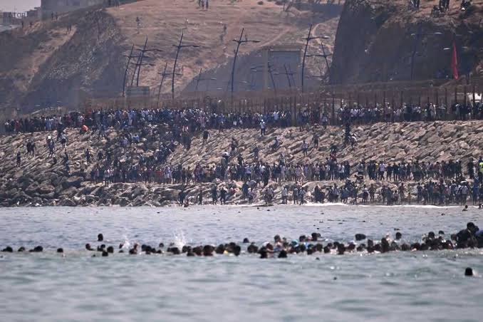 Centinaia di persone attraversano a nuoto e via terra il confine di Ceuta, sorvegliate dalle forze dell'ordine